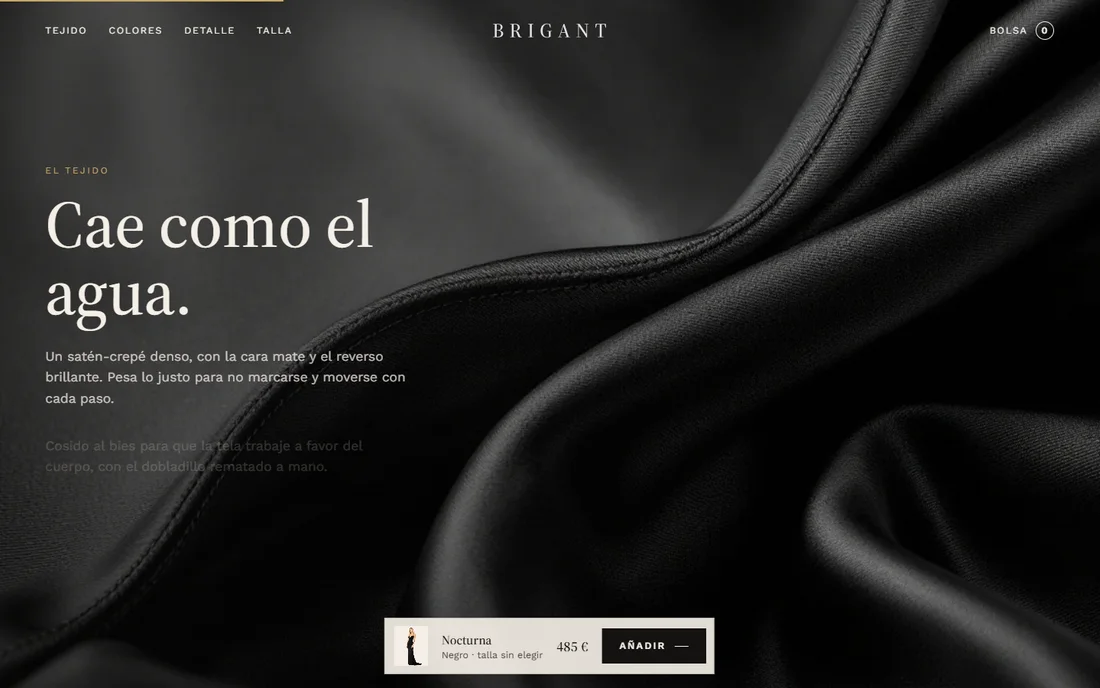 Primer plano del satén negro del vestido Nocturna, con el texto «Cae como el agua» sobre el tejido